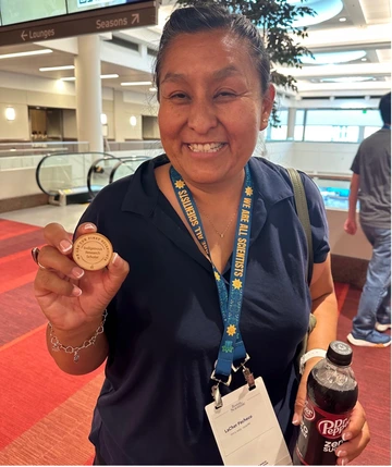 U of A PhD Student LaCher Pacheco shows off her more than deserved award token