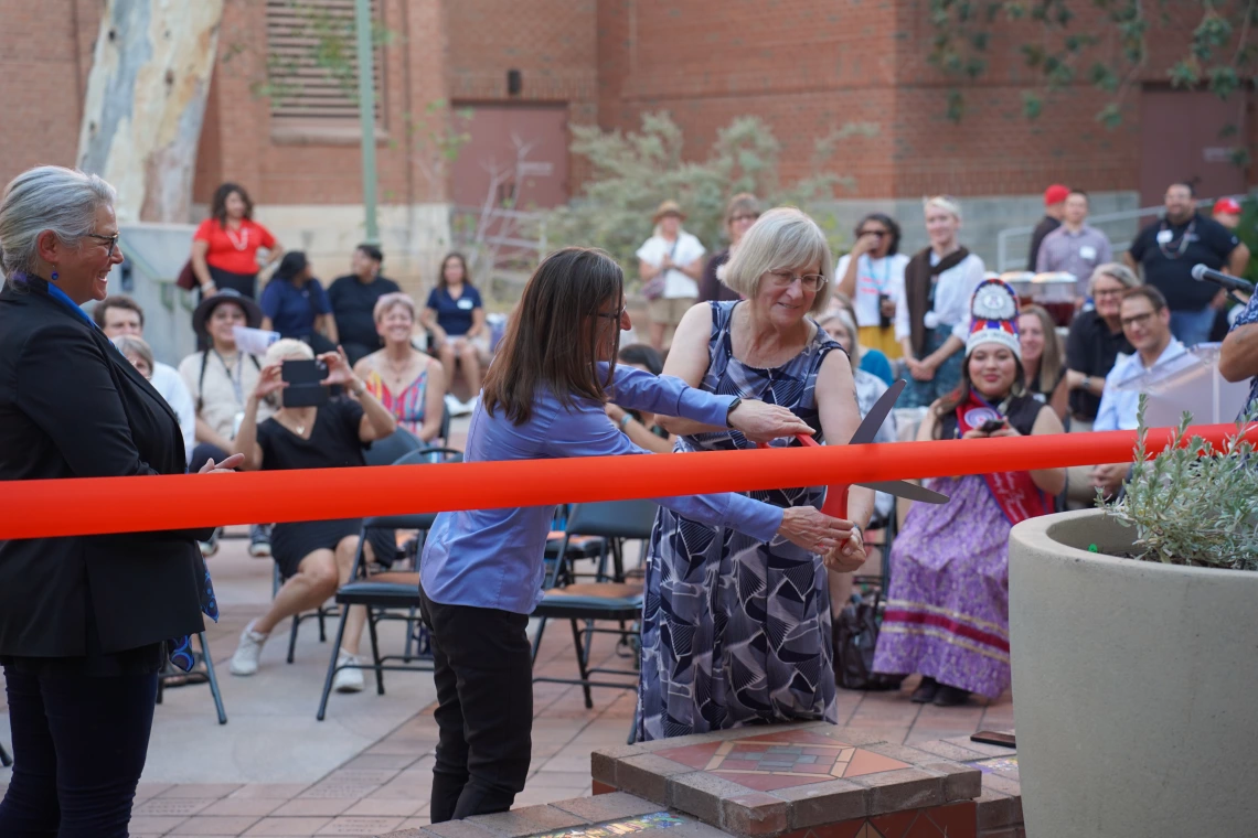 Mary Grier and Nancy Petersen cutting the ribbon to open Ms. Haury's garden.